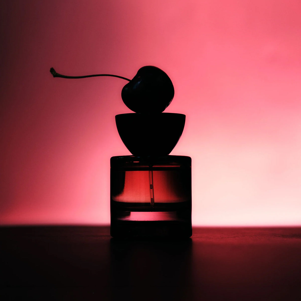 Vyrao EVER 11 Eau de Parfum bottle silhouetted in dark and moody lighting in a dark and pink atmosphere