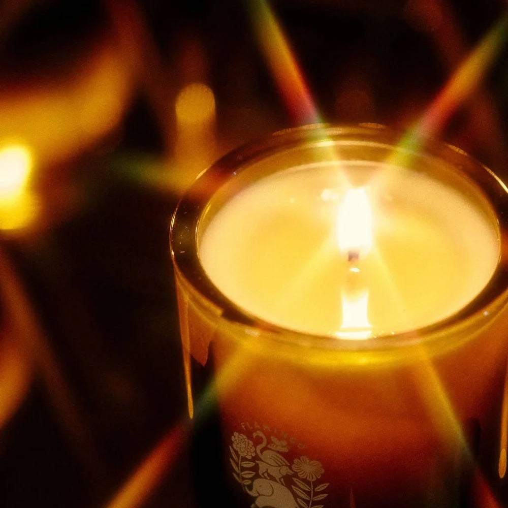 Candle in a decorative holder with a warm glow against a blurred background