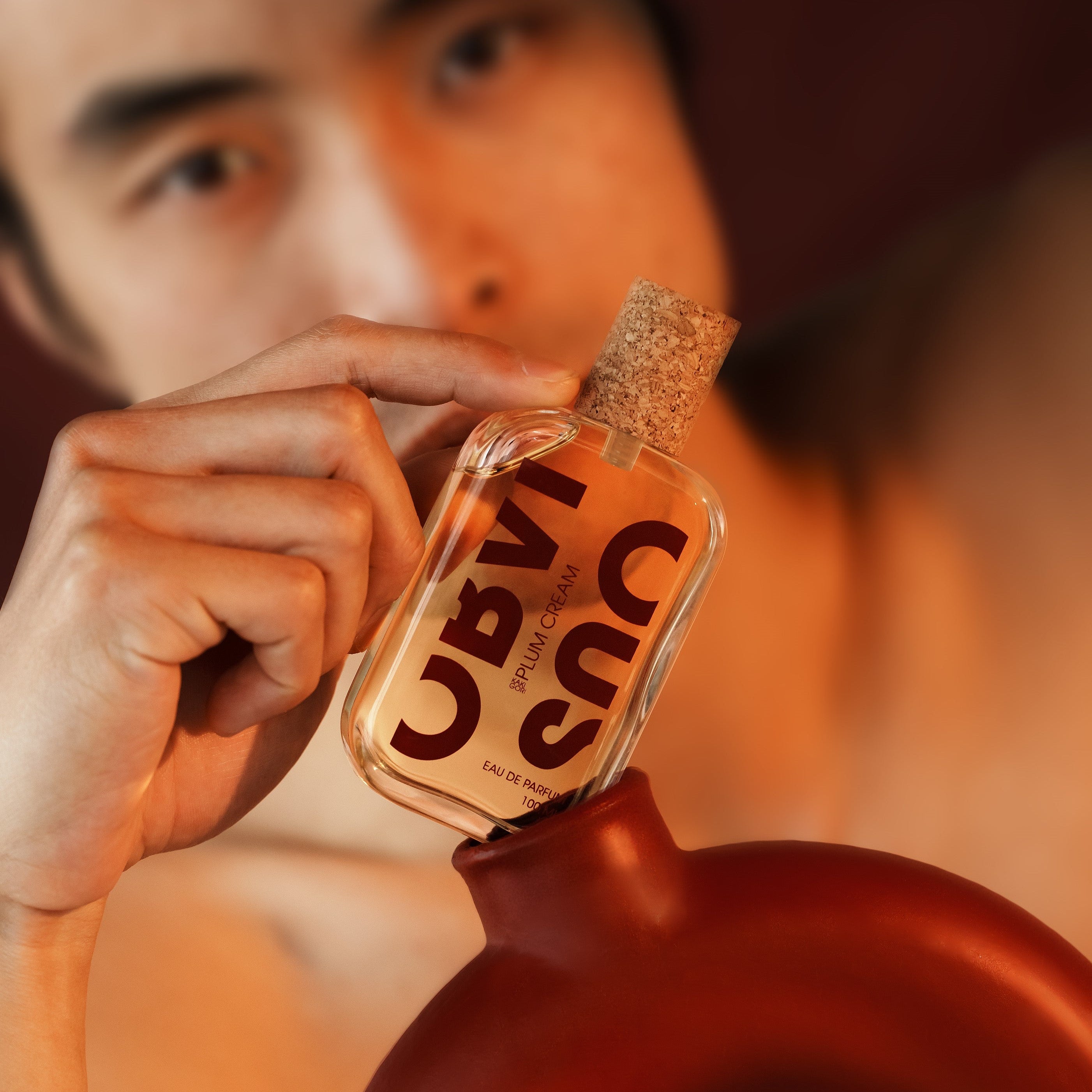 Person holding a perfume bottle with a blurred background