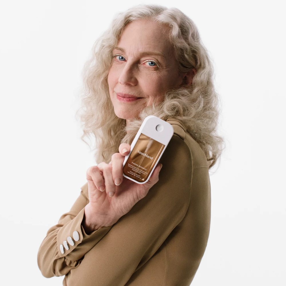Woman holding a bottle of product against a white background