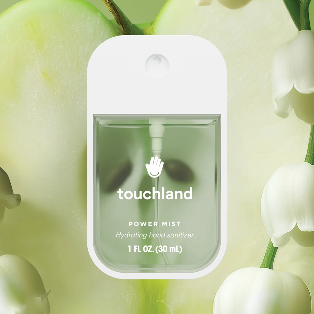 Touchland power mist hand sanitizer packaging with green apples and white flowers in the background