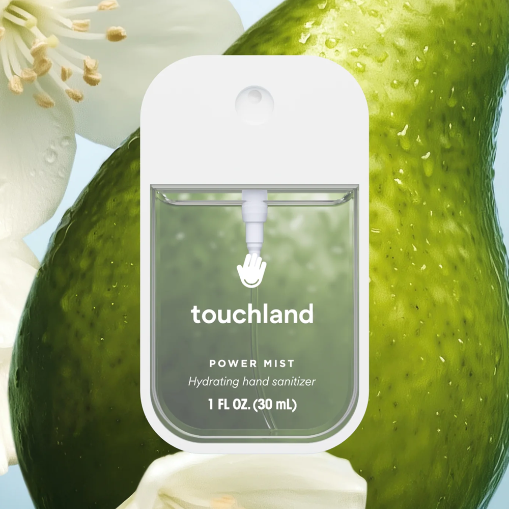 Touchland power mist hand sanitizer on a green fruit with white flowers