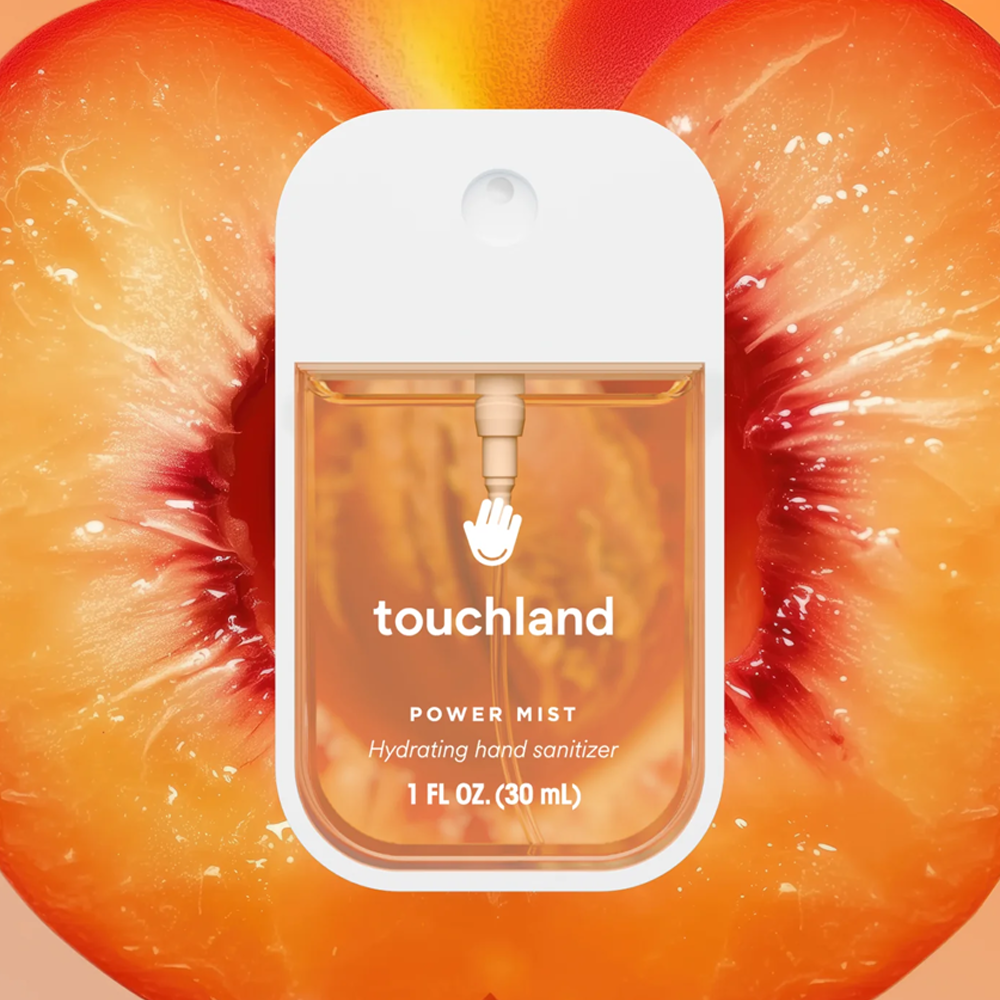 Touchland power mist hand sanitizer packaging on a peach background