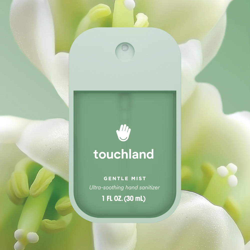Green hand sanitizer bottle with 'touchland' branding on a floral background