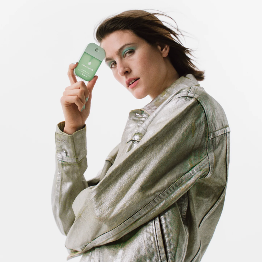 Woman holding touchland product against a white background