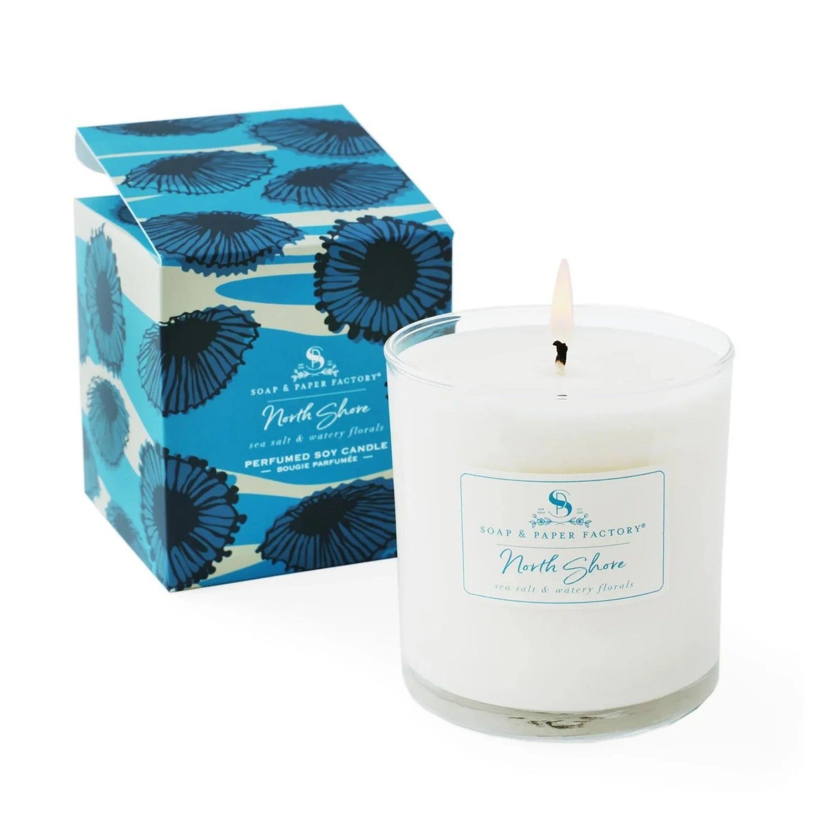 White candle with a blue floral box on a white background