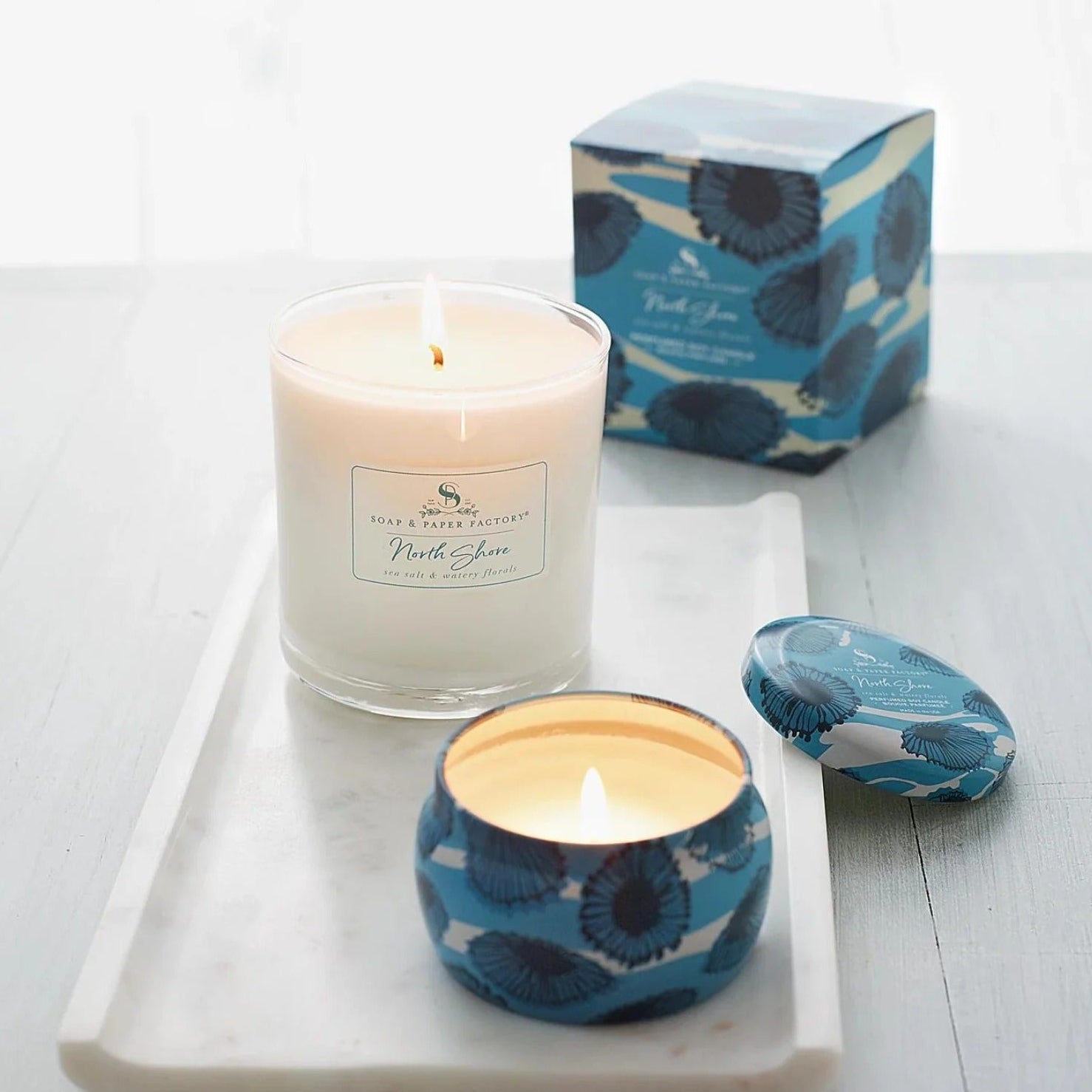 Candle with a blue floral design on a white surface