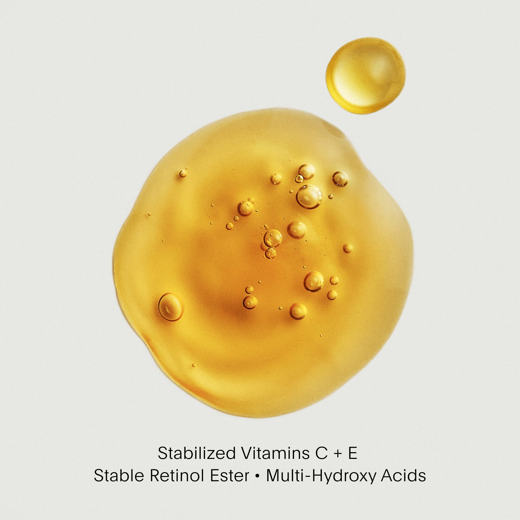 Gold-colored droplet with bubbles on a light gray background, labeled with skincare ingredients.