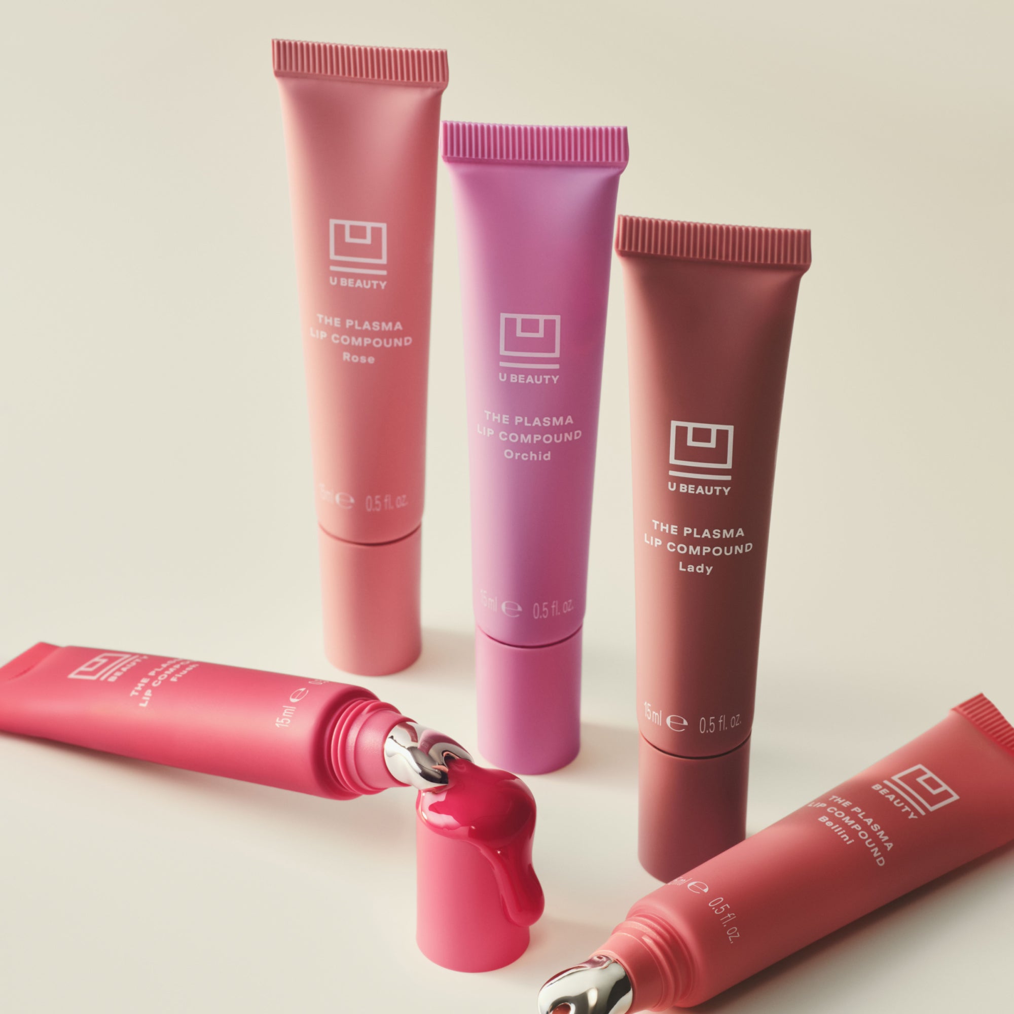 Set of pink and purple cosmetic tubes with visible branding on a light background