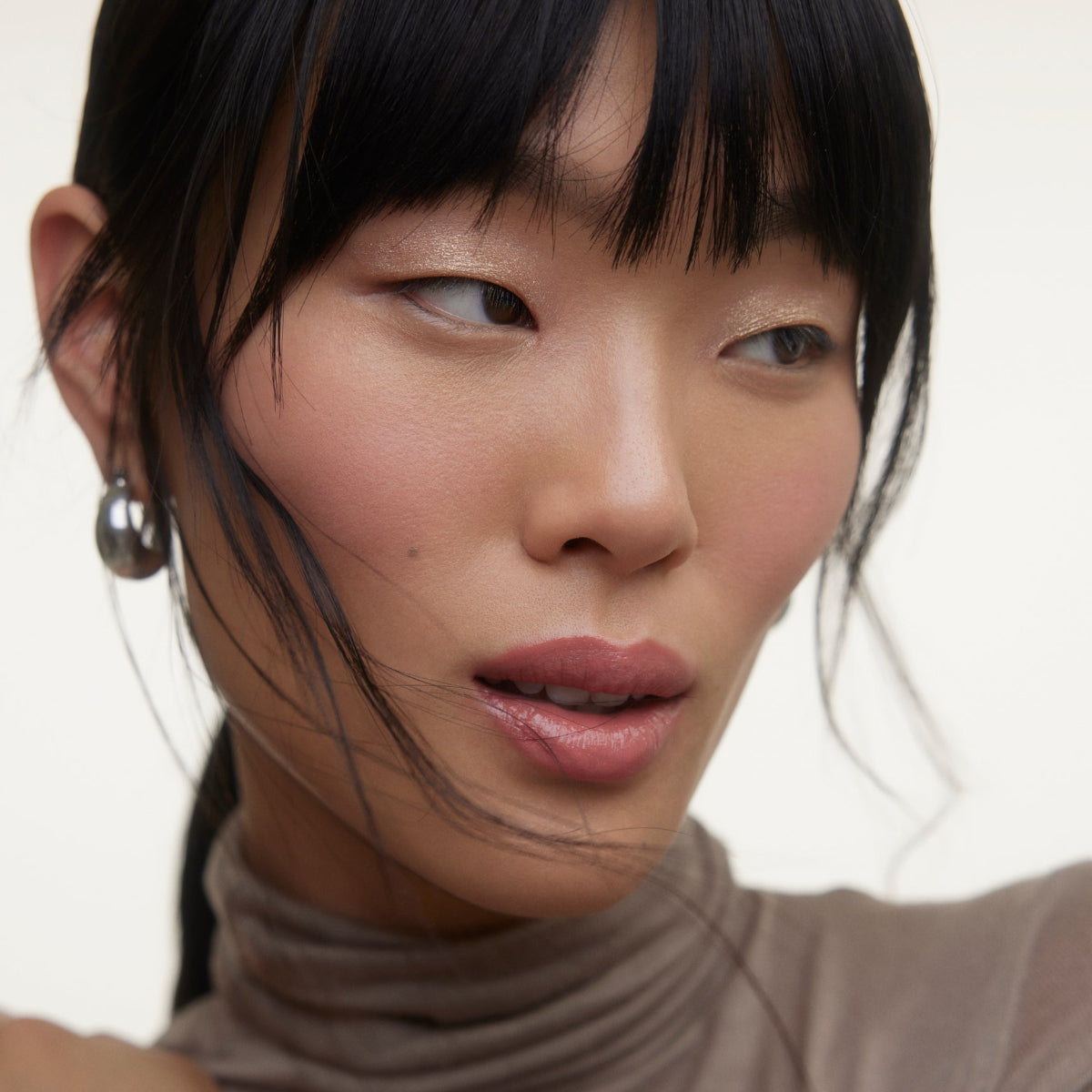 Closeup of woman's face wearing Wonderblush makeup products. 
