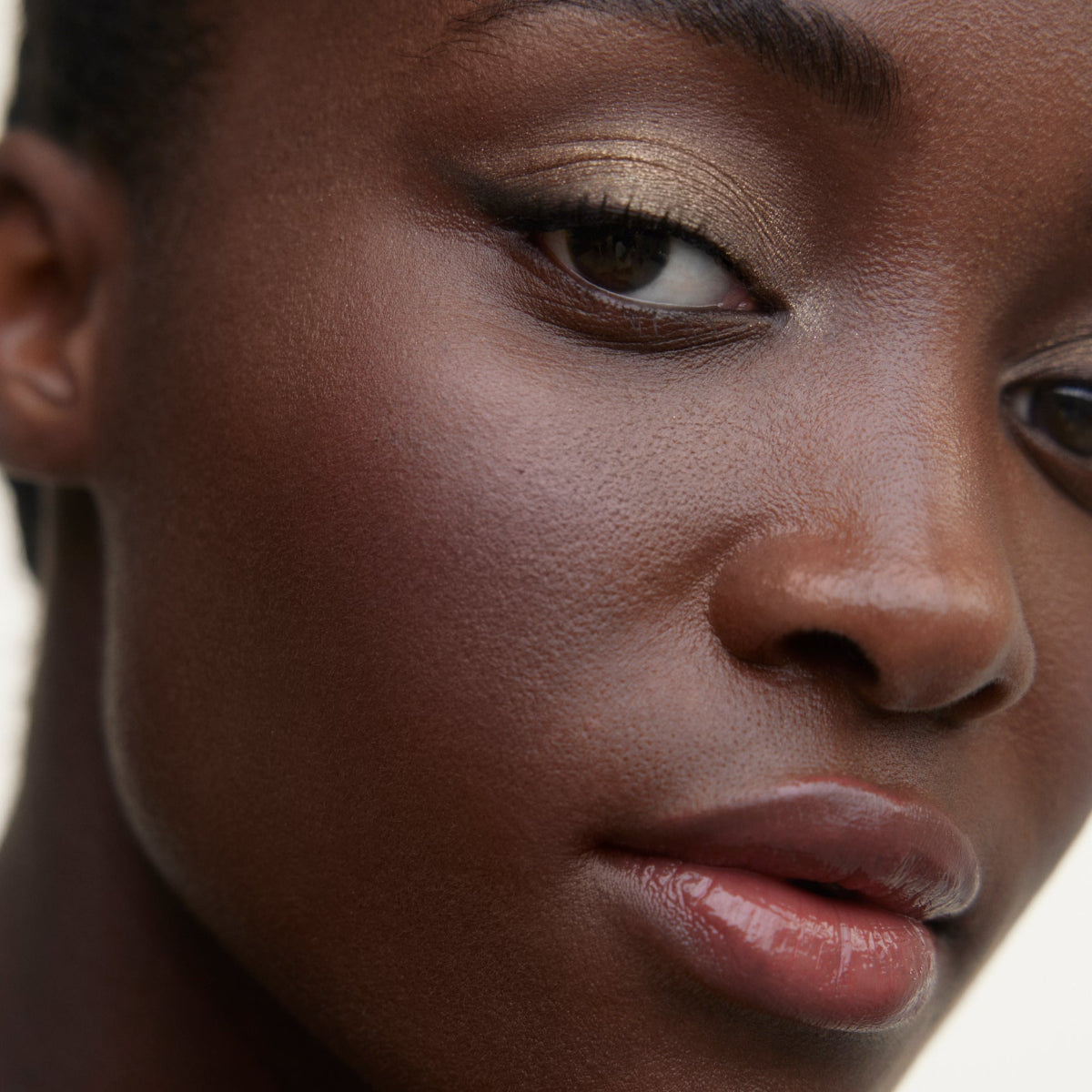 Closeup of woman's face wearing Wonderblush makeup products. 