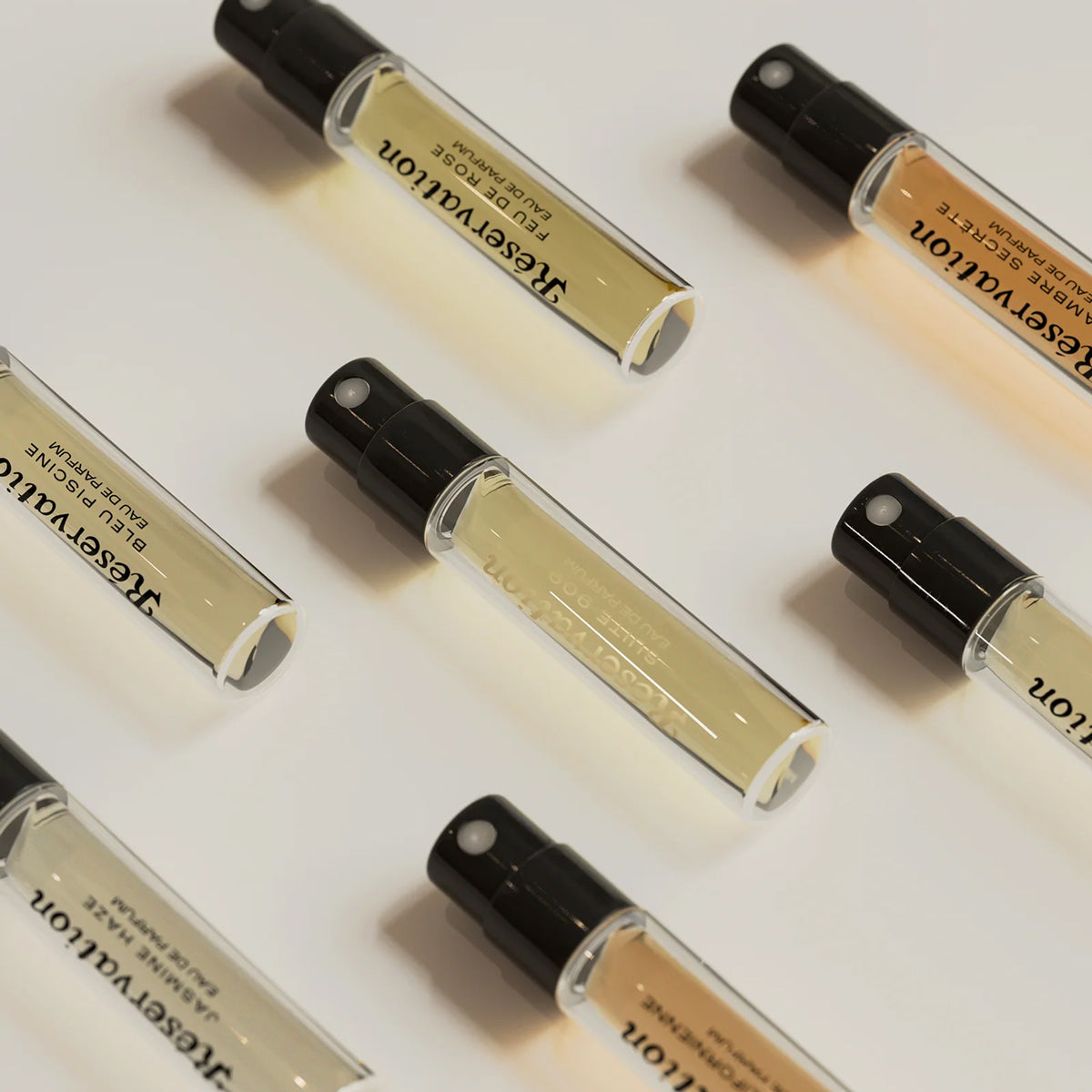 Multiple small perfume bottles with 'Reseravalon' branding on a light background