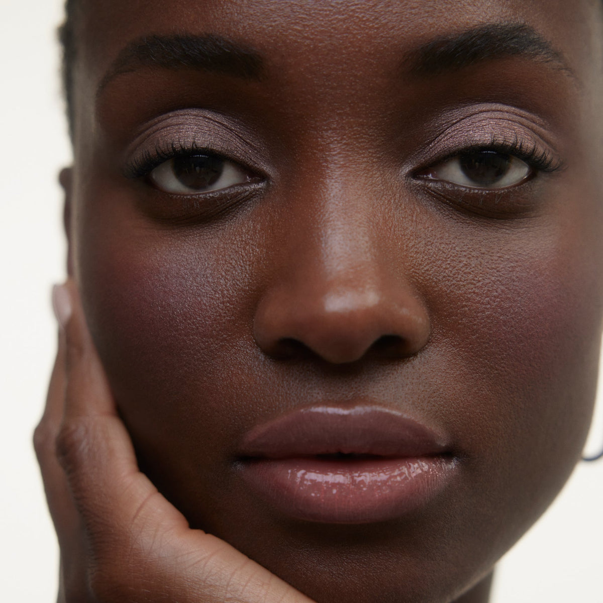 Closeup of woman's face wearing Wonderblush makeup products. 