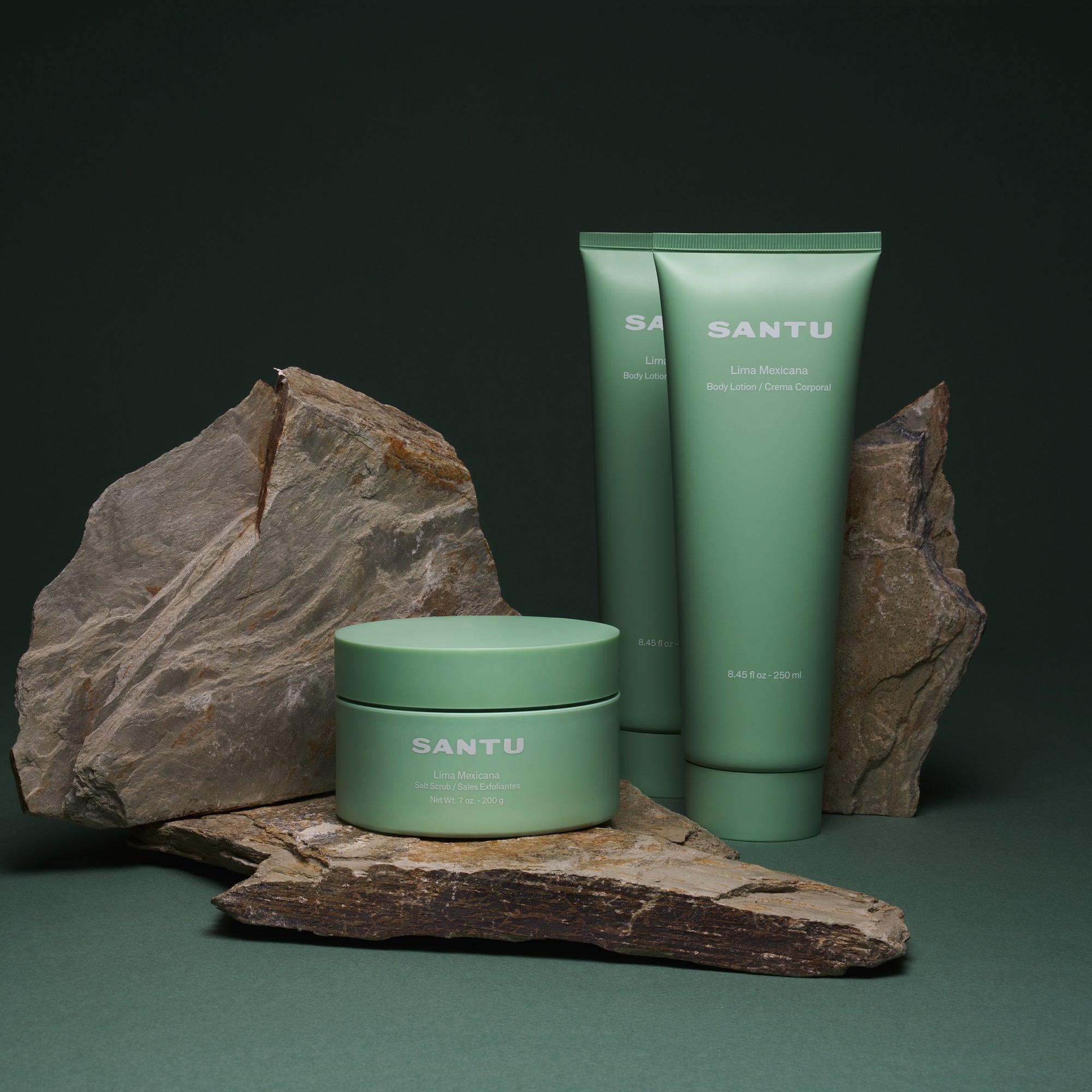 Green skincare products with 'Santu' branding on stones in front of a dark background