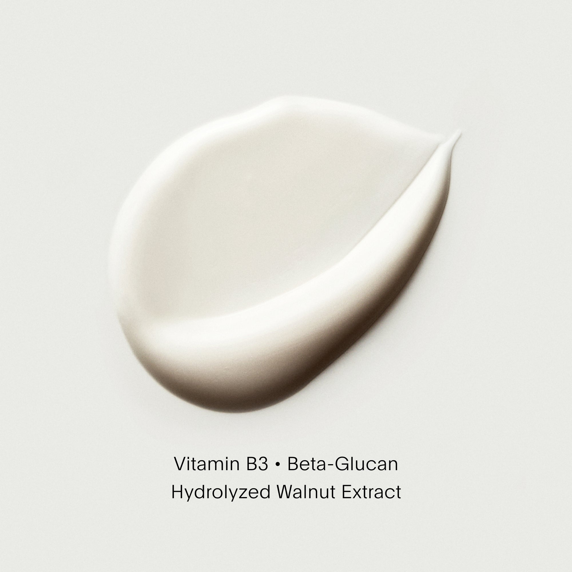 Close-up of a droplet of cream with text on a light gray background