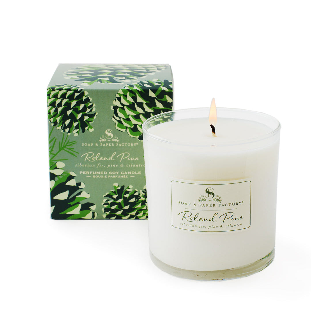 White candle with 'Roland Pine' label and green decorative box on a white background