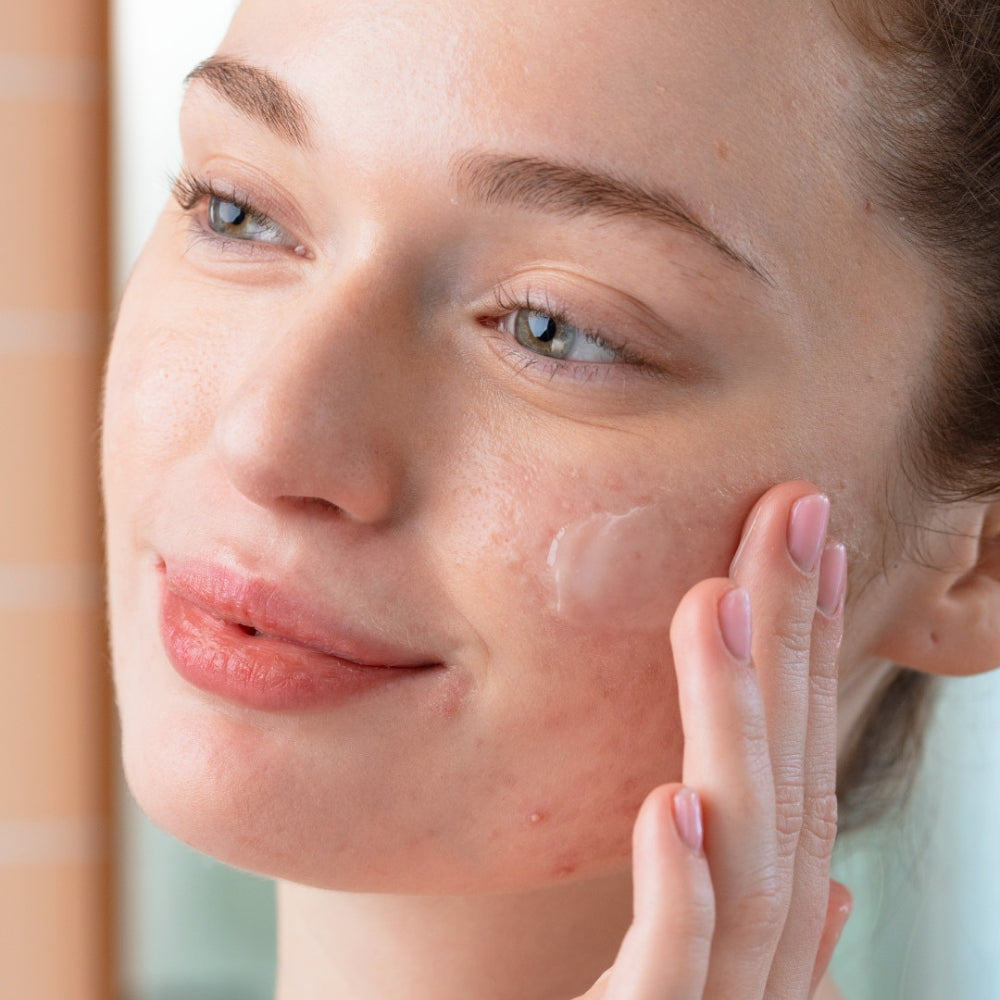 Woman applying cream to her face with a blurred background