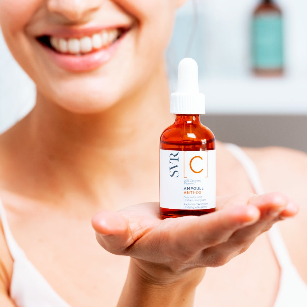Person holding a bottle of SVR C Radiance Concentrate Ampoule bottle in their hand. 