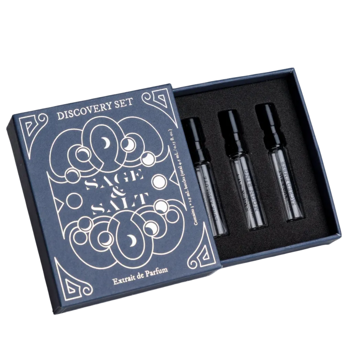 A perfume discovery set box in navy blue with white line art and the words 'SAGE & SALT' and 'Extrait de Parfum' on the lid. The open box contains three small black perfume sample vials on a white background.