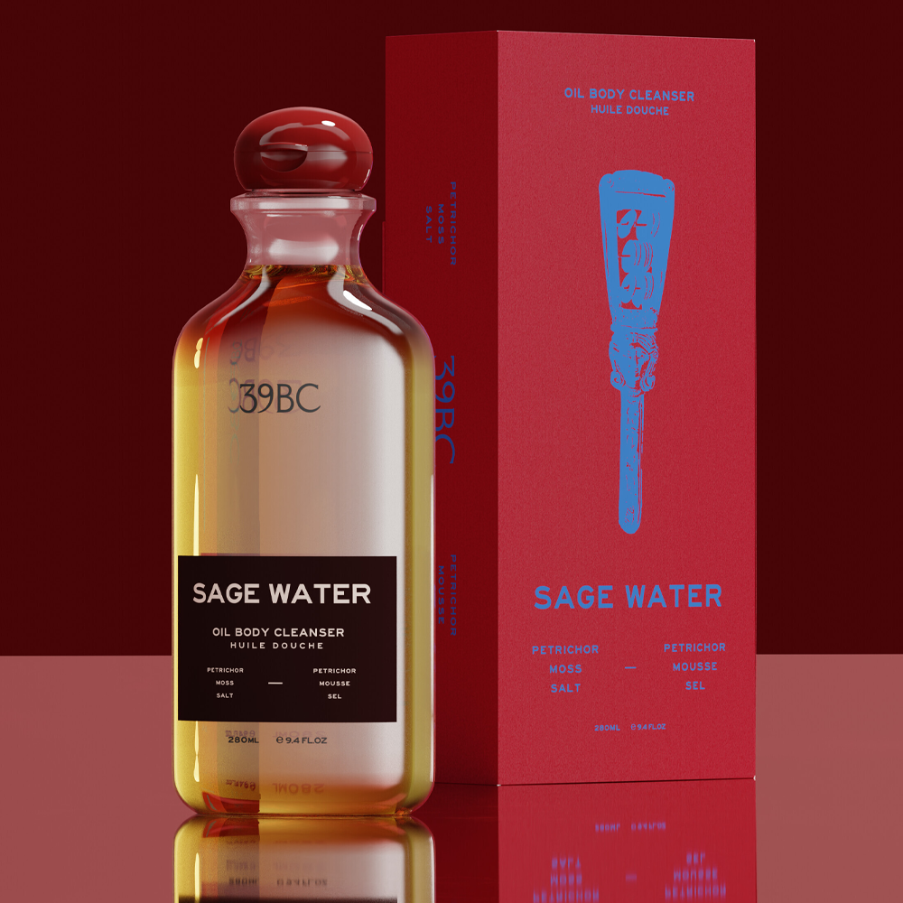A Bottle of 39BC Sage Water Oil Body Cleanser with amber liquid and a black label, standing next to its red packaging box with a blue applicator graphic, on a dark red reflective background.