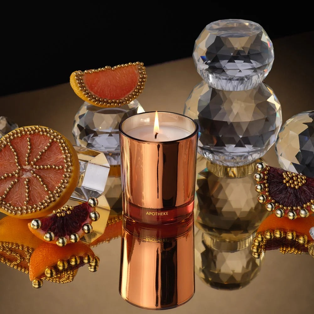 Copper candle with decorative elements on a reflective surface