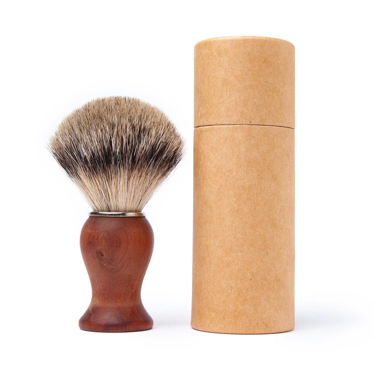 Shaving brush with wooden handle and brown bristles next to a cardboard tube on a white background