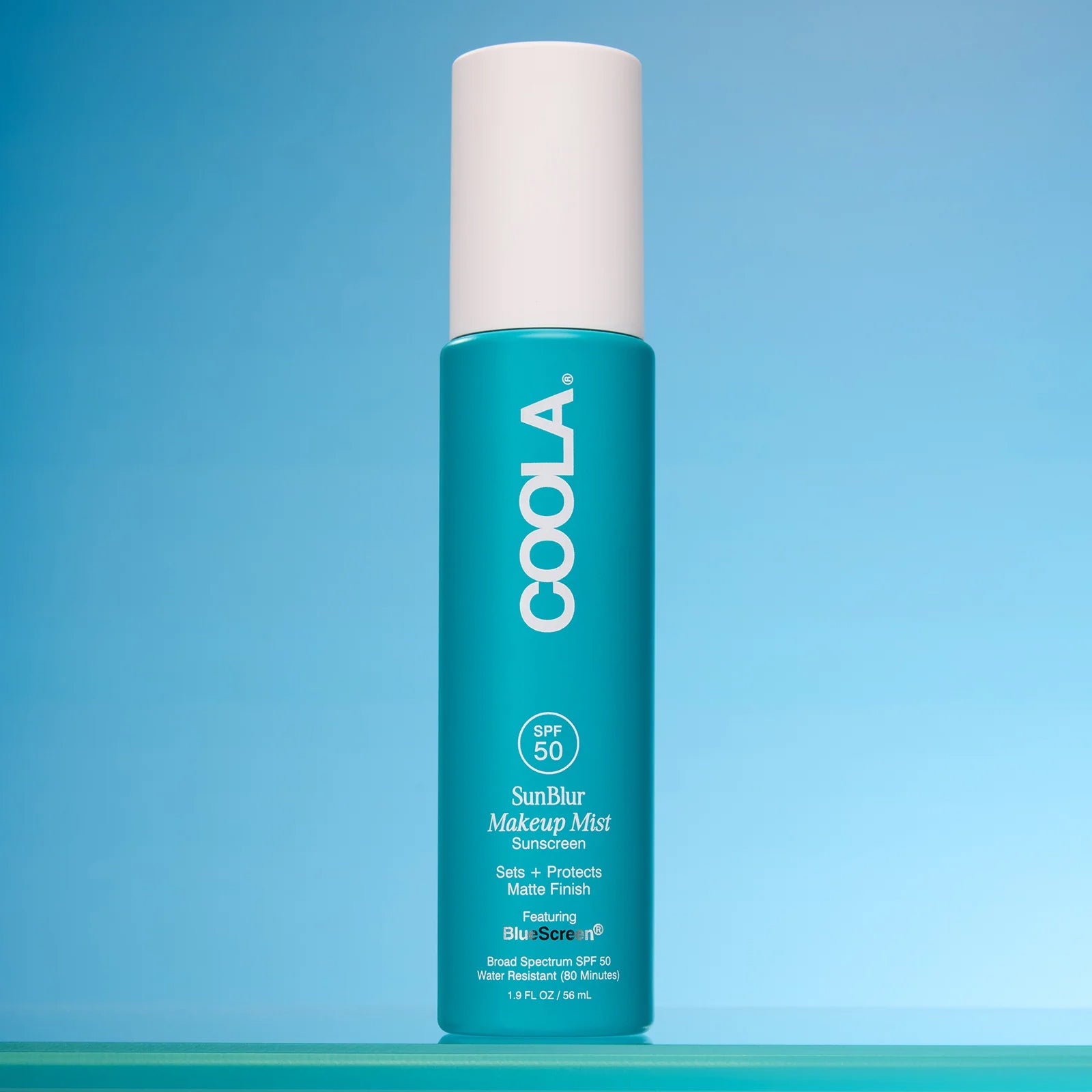 COOLA SunBlur Makeup Mist product on a blue background