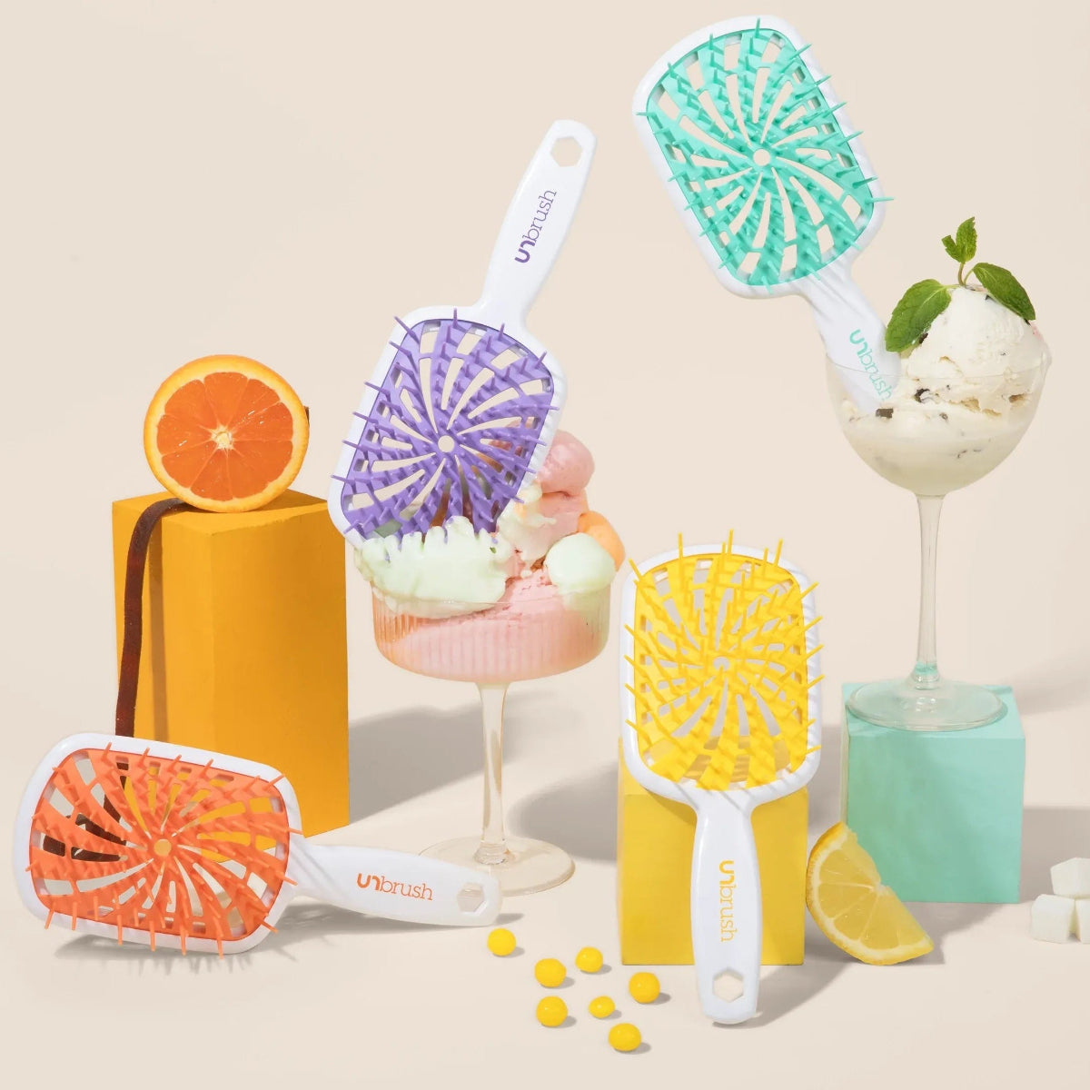 Set of colorful ice cream in glasses and the UNbrush Plus Collection on a beige background