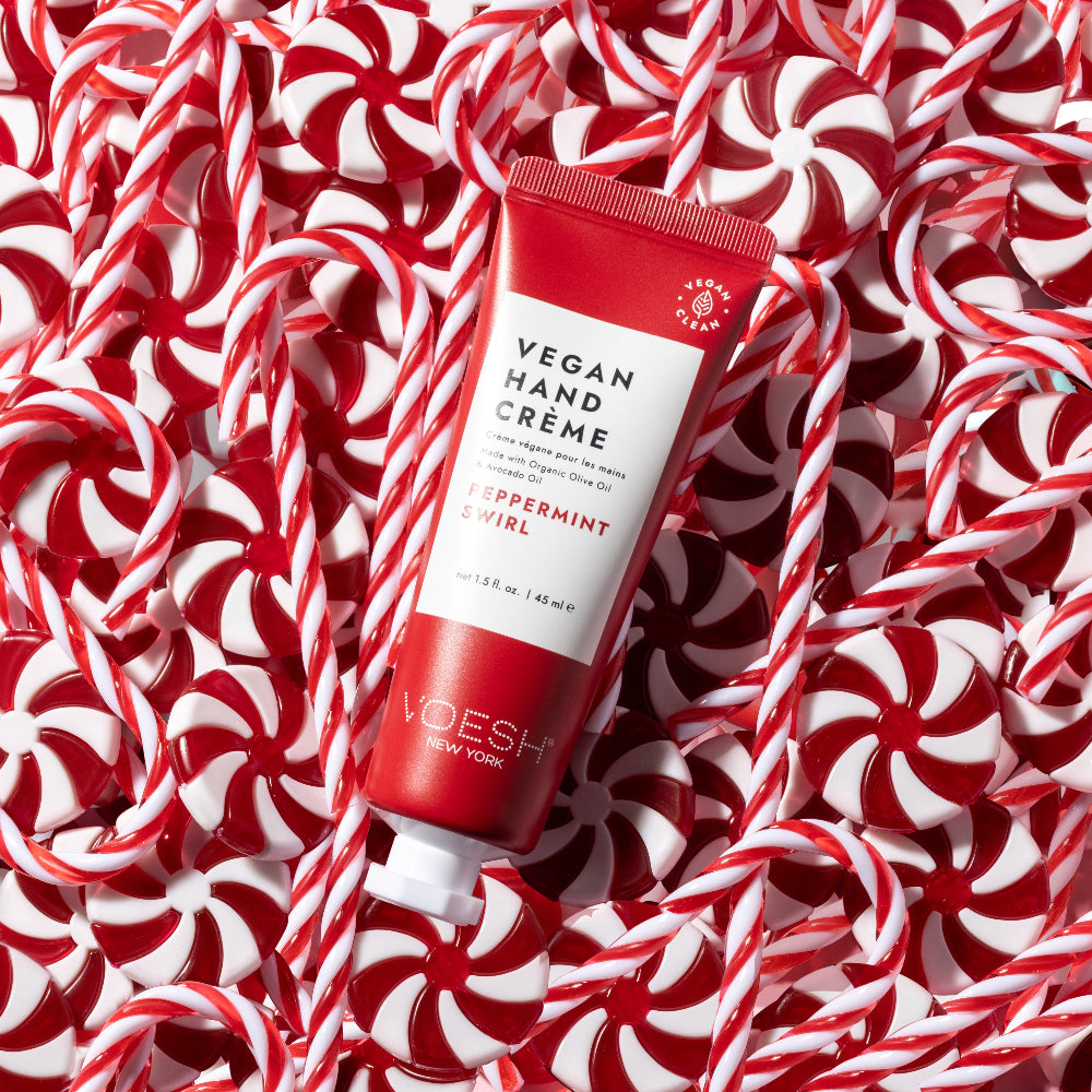 Red tube of vegan hand cream on a background of peppermint candies