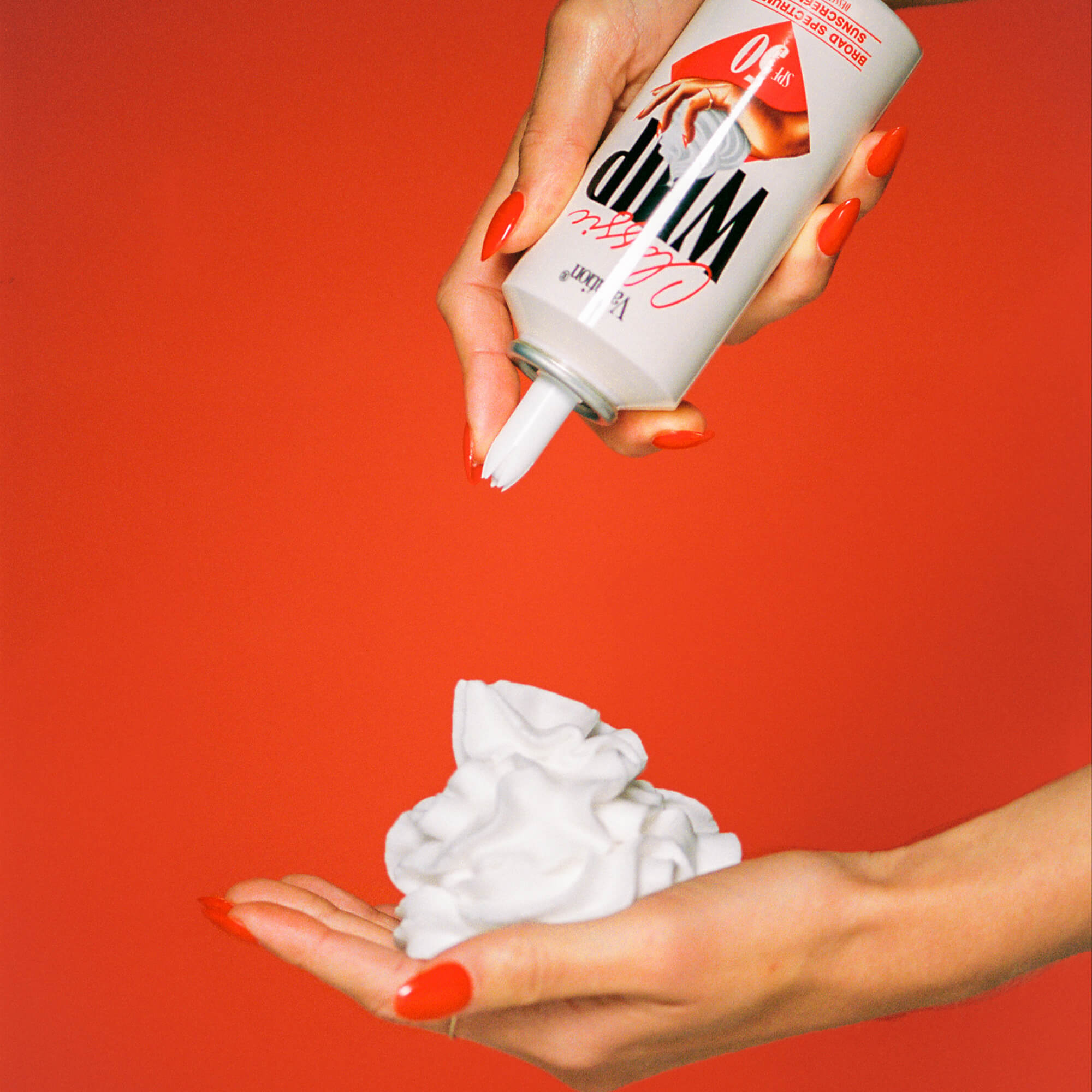 Hand holding a can of Classic Whip with a red background
