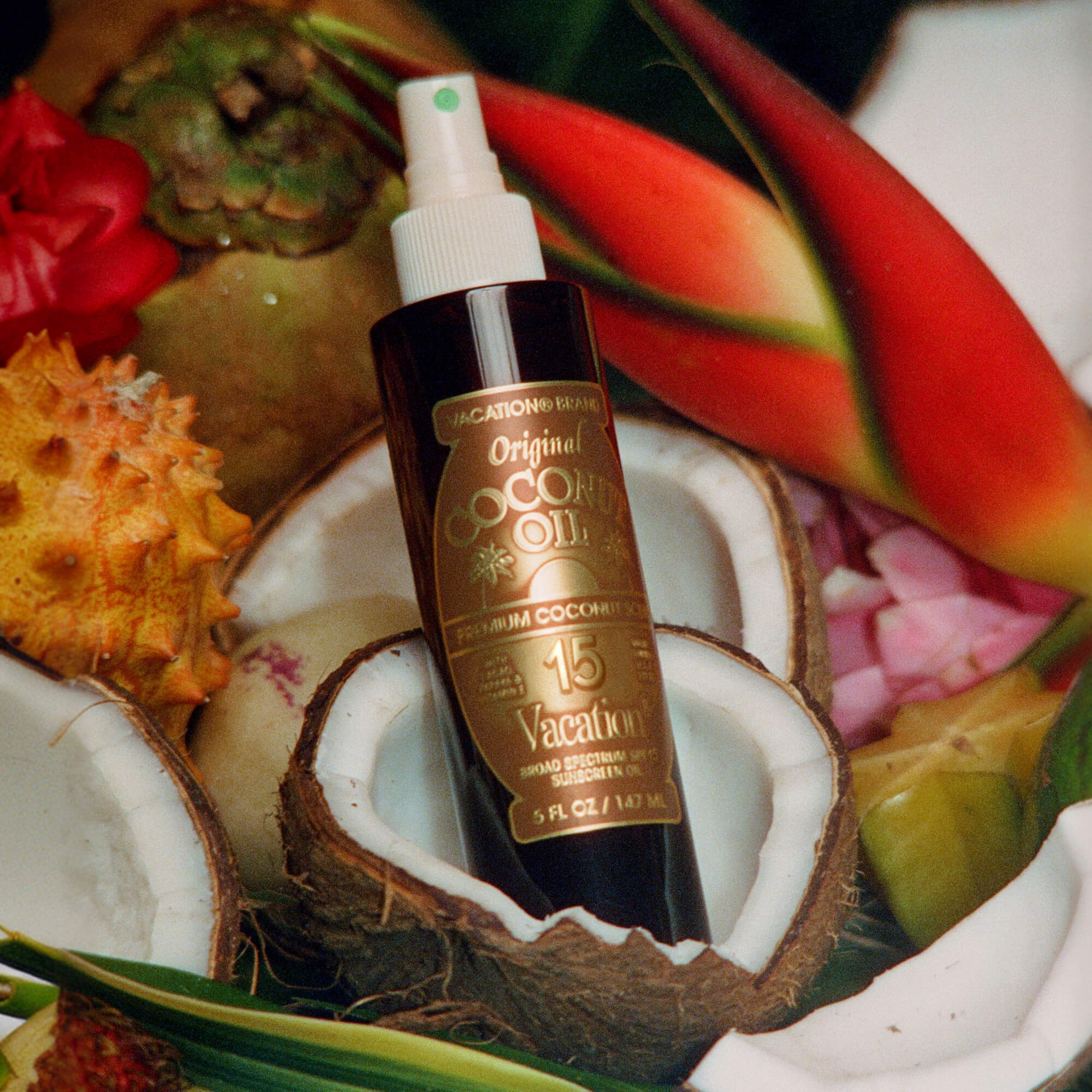 Coconut oil bottle with a tropical background featuring coconuts and flowers.