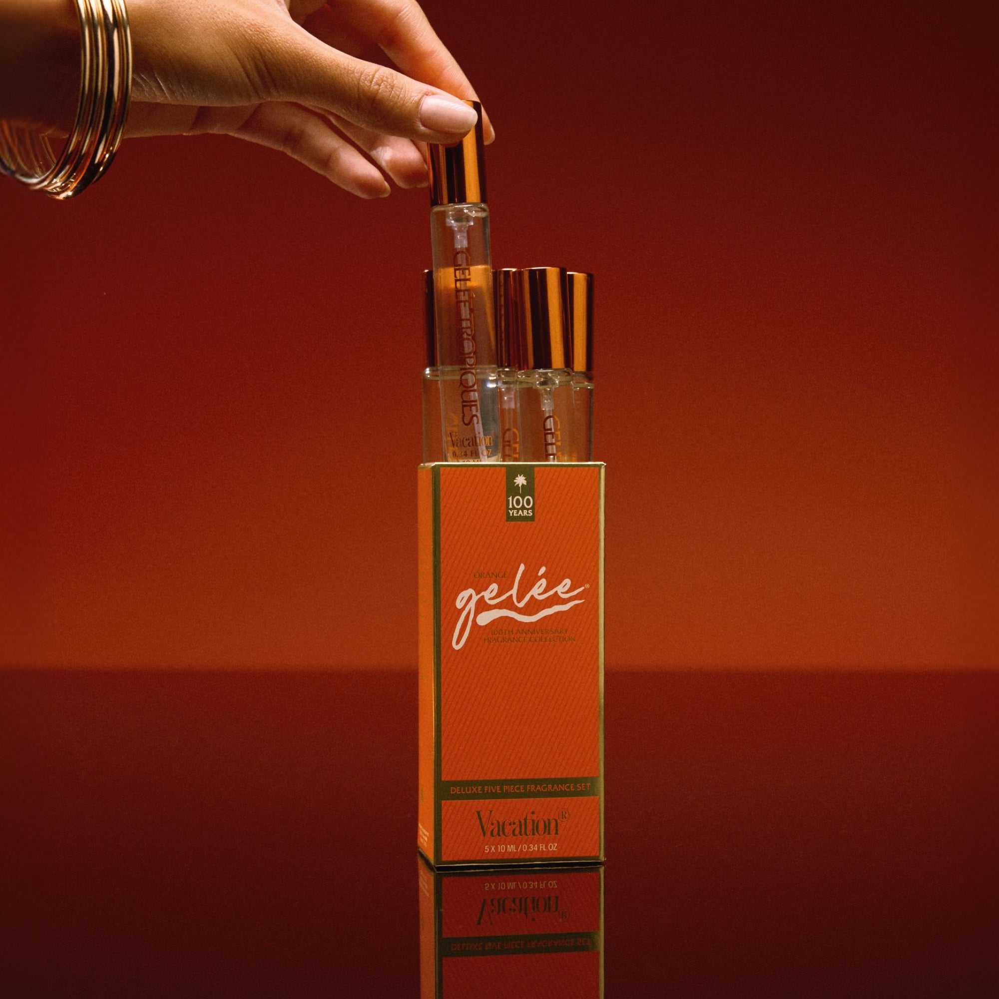 Perfume bottles with an orange box labeled 'geée' on a red background