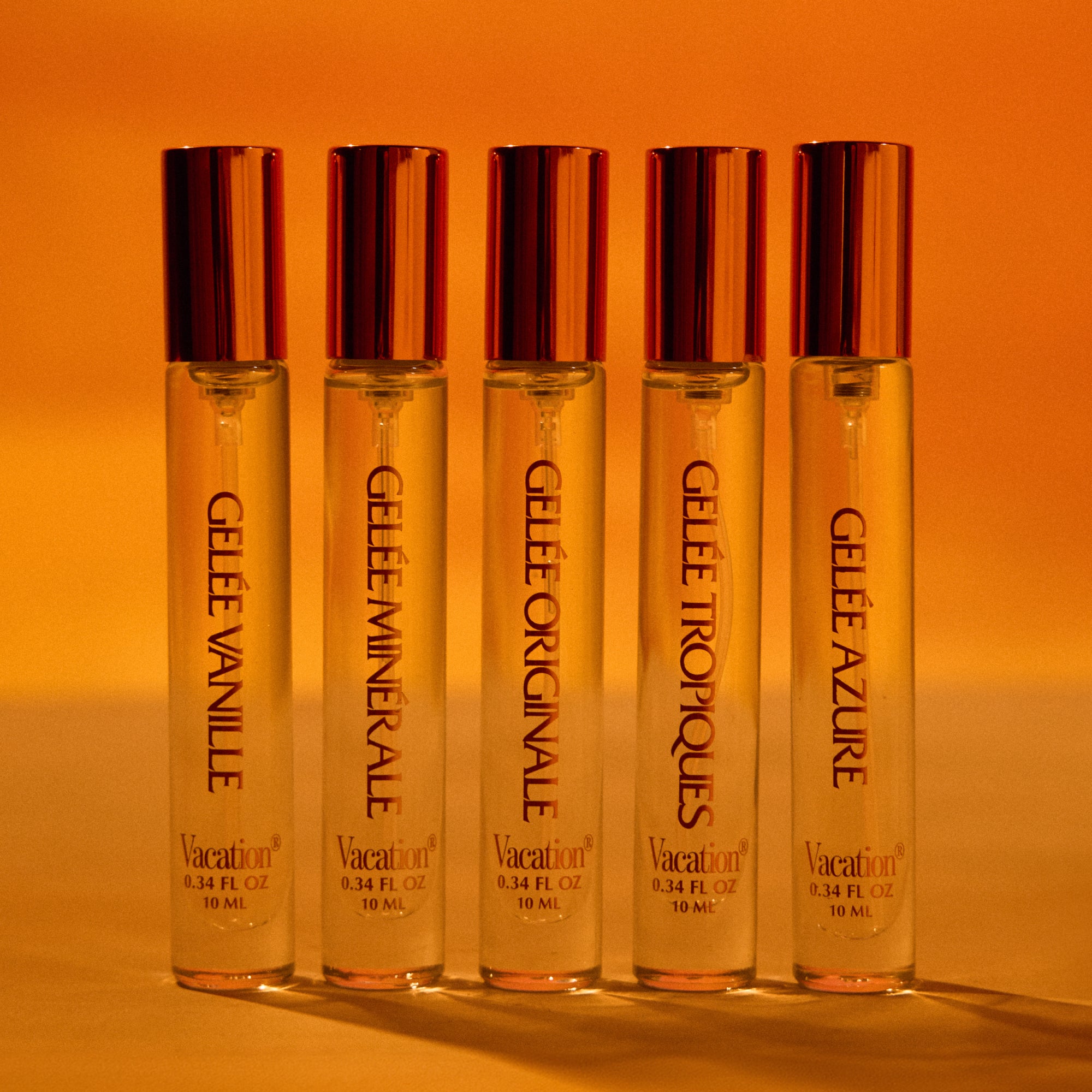 Five Gelèé perfume bottles on an orange background