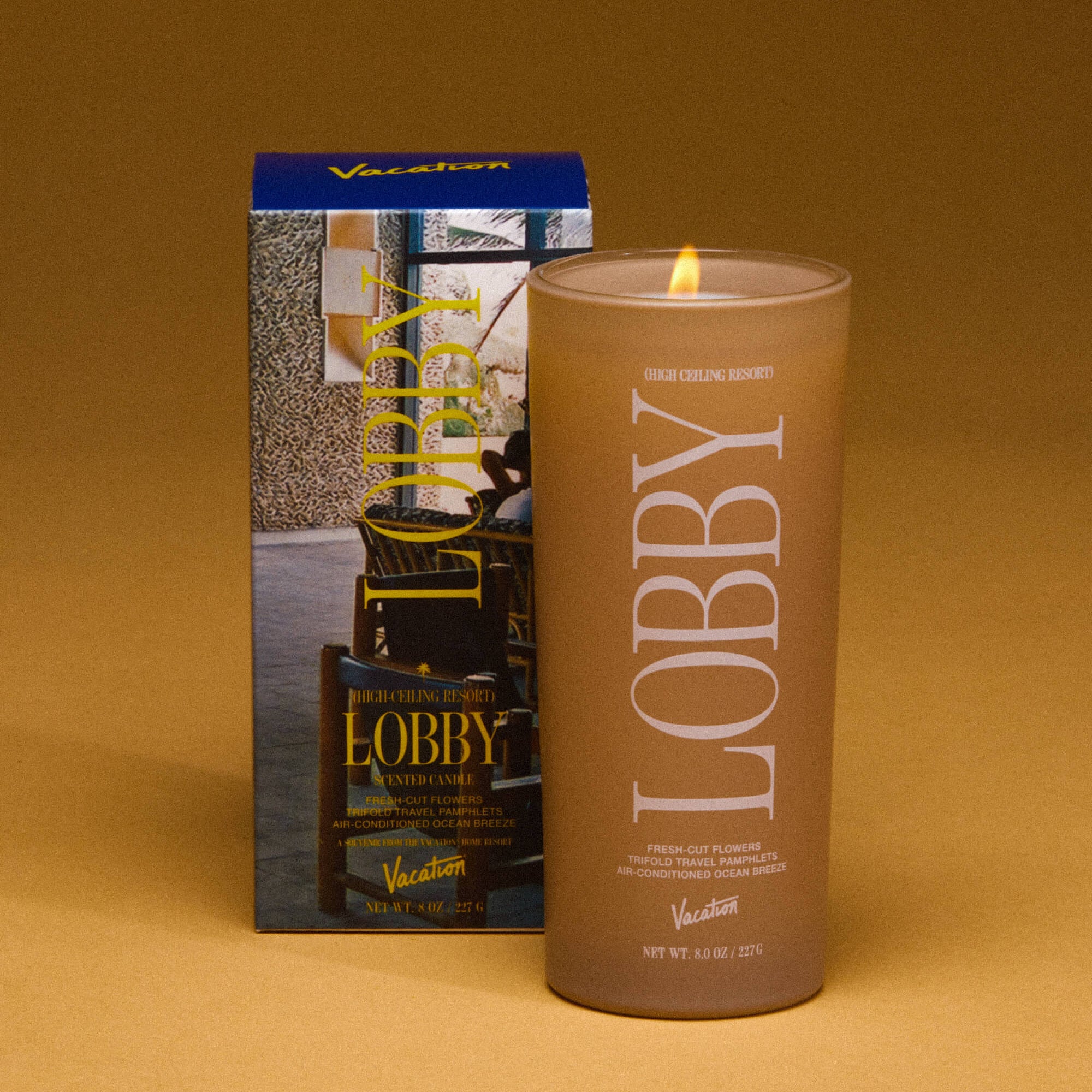 Candle labeled 'Lobby' with packaging on a brown background