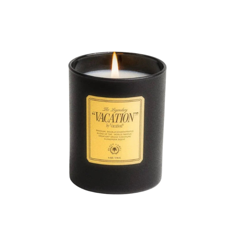 Black candle with a yellow label on a white background