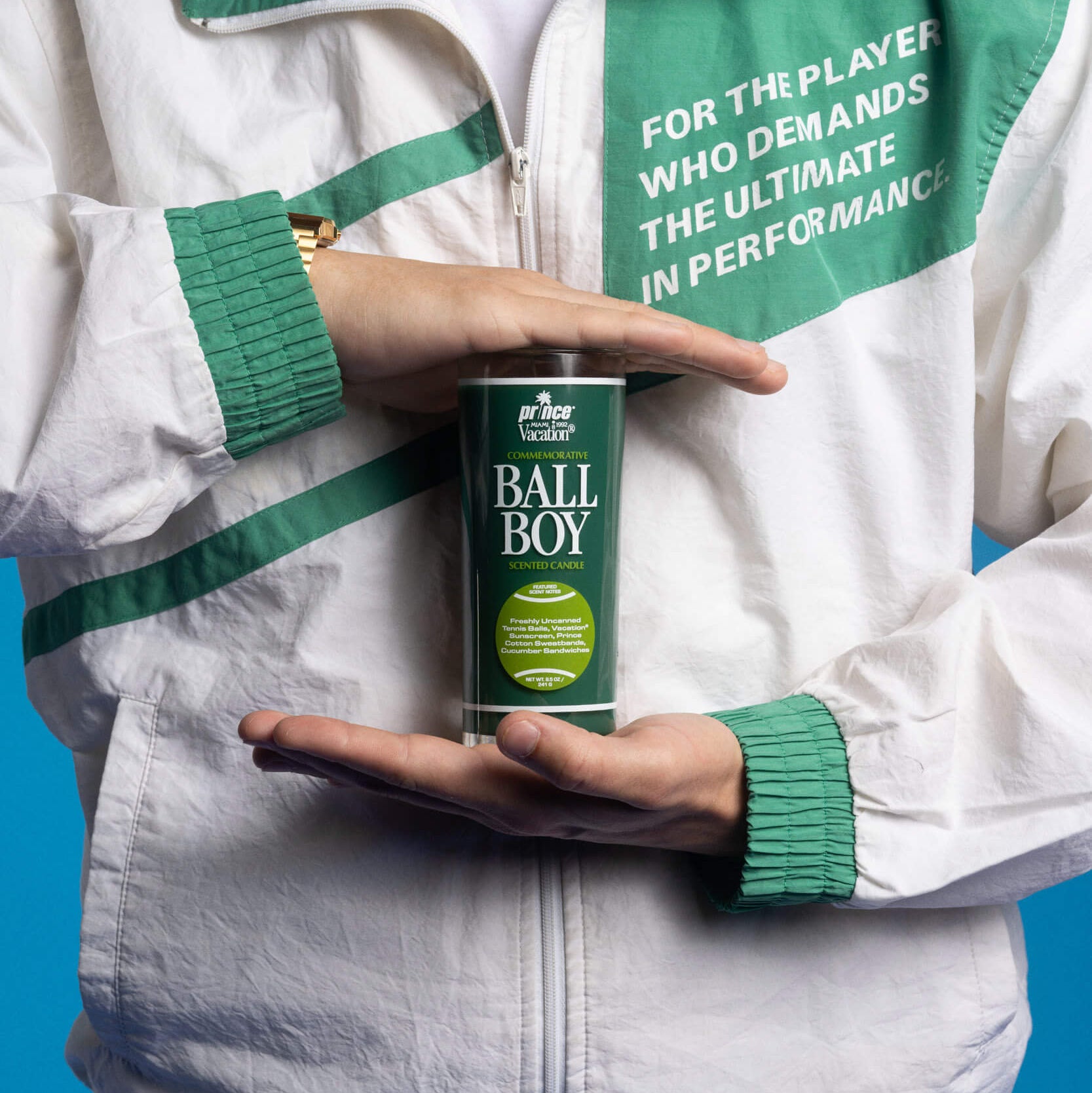 Person holding a can of Ball Boy tennis ball canister against a blue background