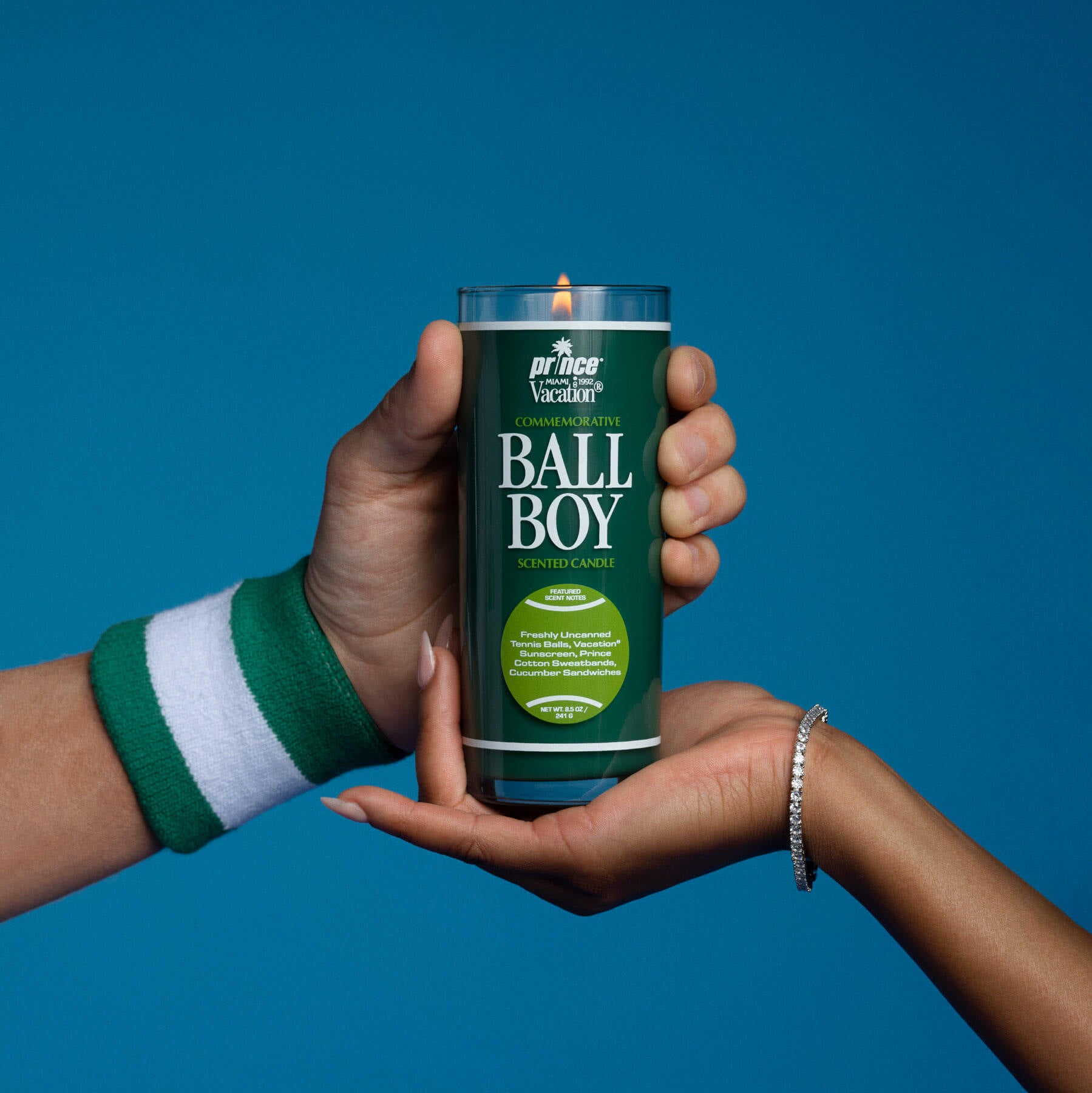 Two hands holding a 'Ball Boy' product can against a blue background