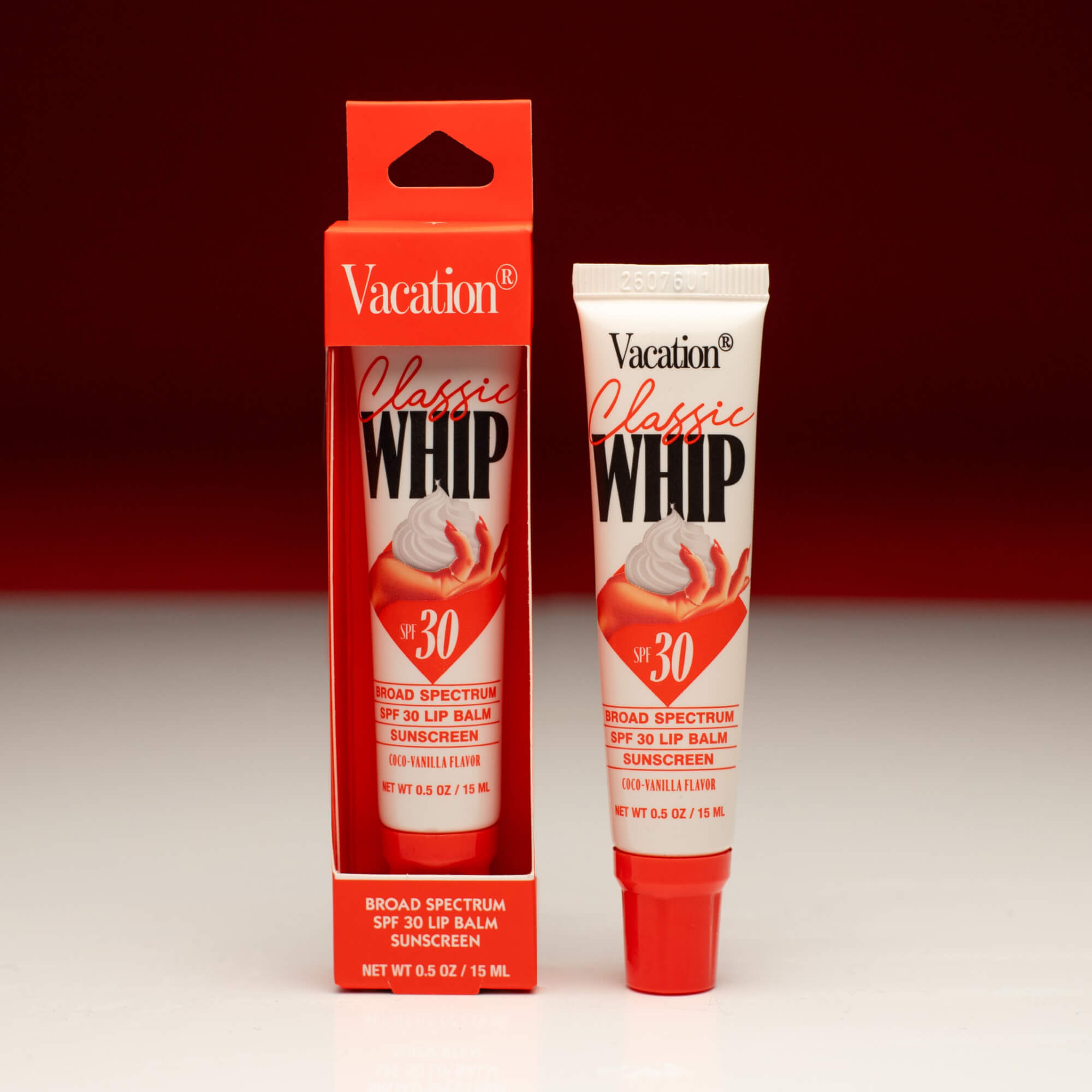 Vacation Classic Whip lip balm packaging and tube on a red background