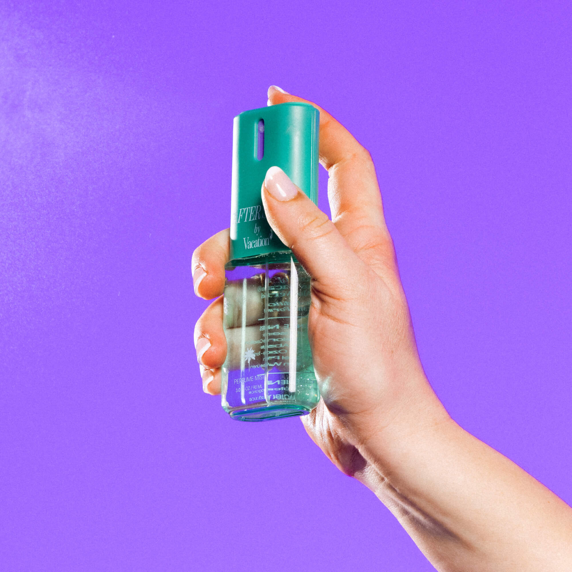 Hand holding a green spray bottle against a purple background