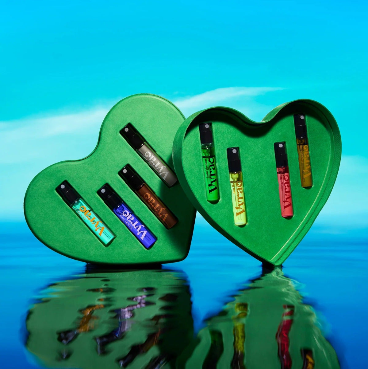 Two green heart-shaped objects with colorful labels on a blue reflective surface.
