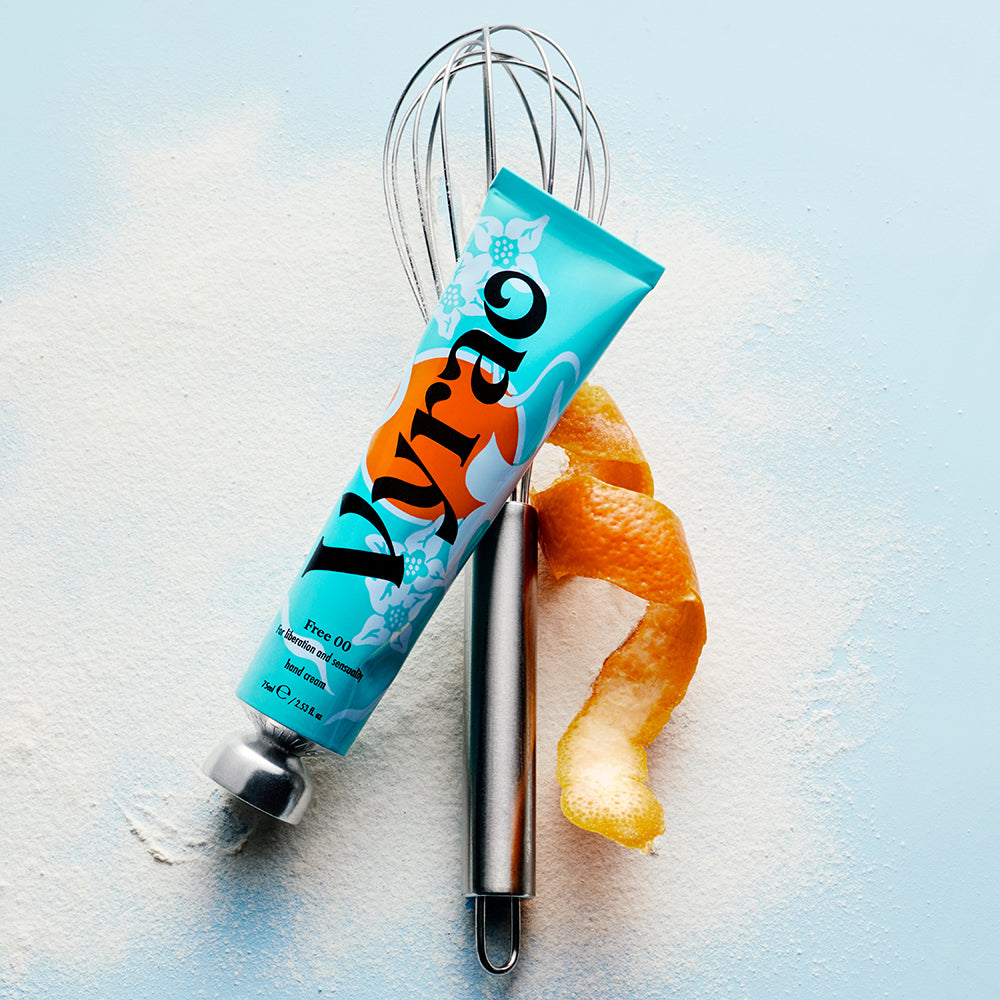 Vyrao tube with an orange peel and whisk on a light blue background
