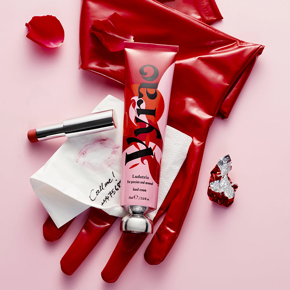 Product tube, gloves, and other items on a pink background