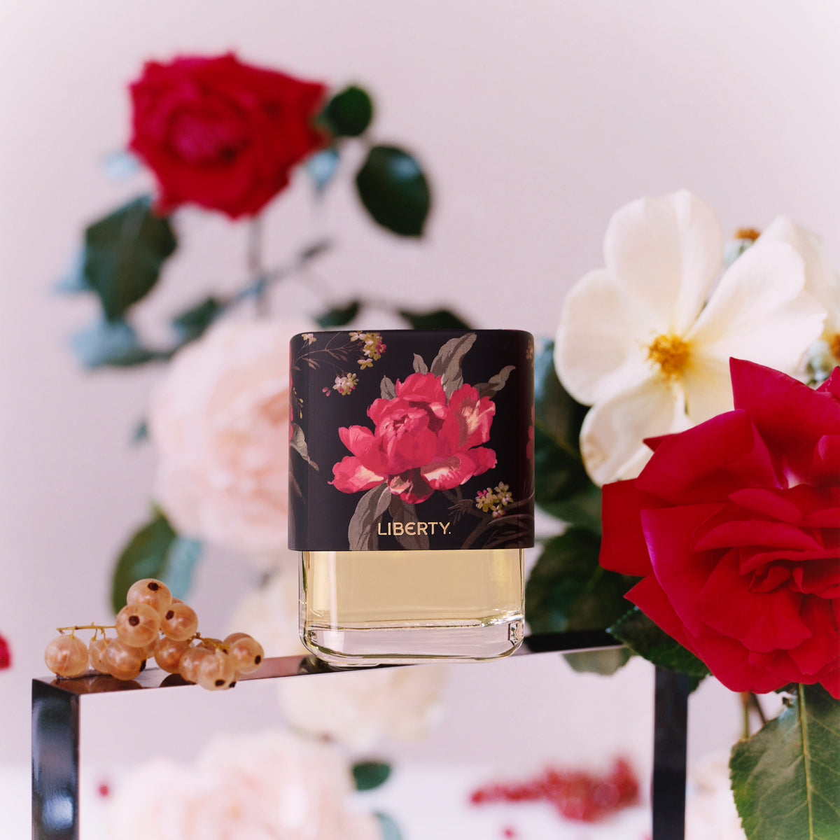 Perfume bottle with floral design on label against a floral background