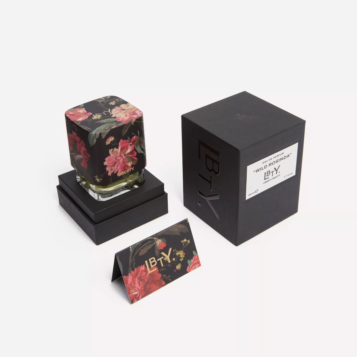 Floral-patterned candle with packaging and card on a white background
