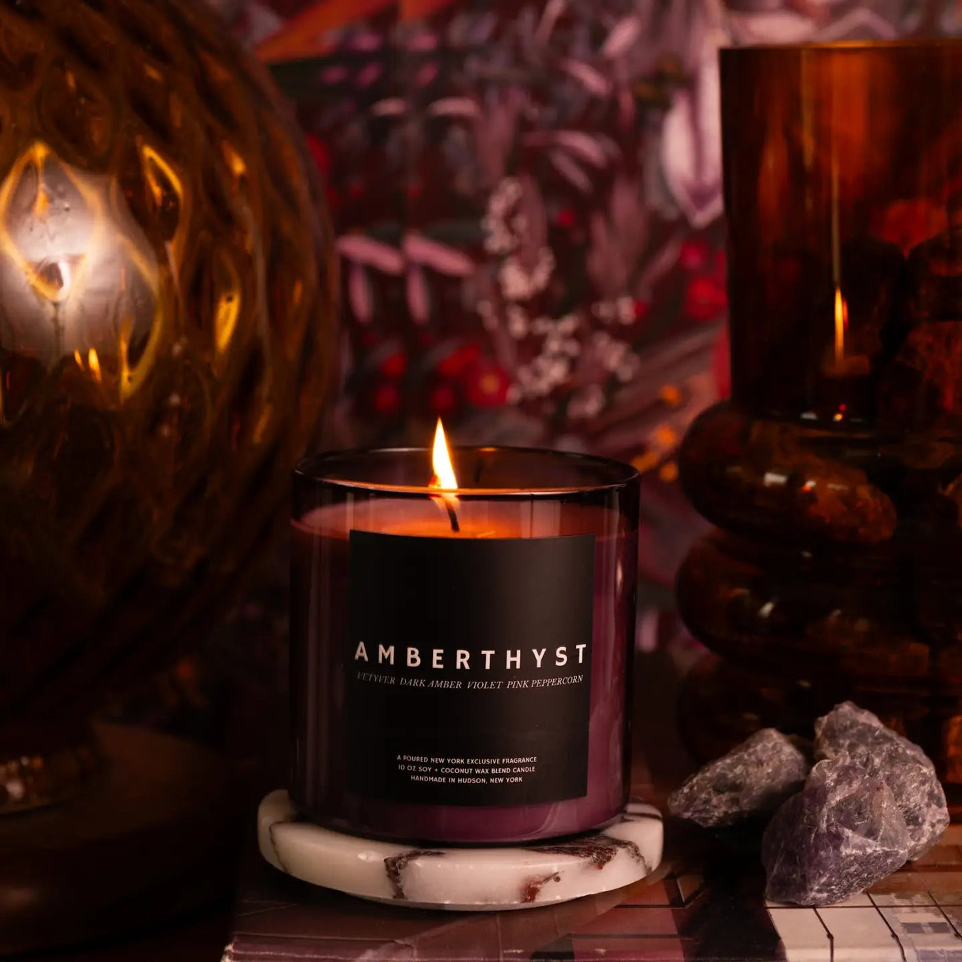 Candle labeled 'Amberthyst' with decorative elements on a dark background