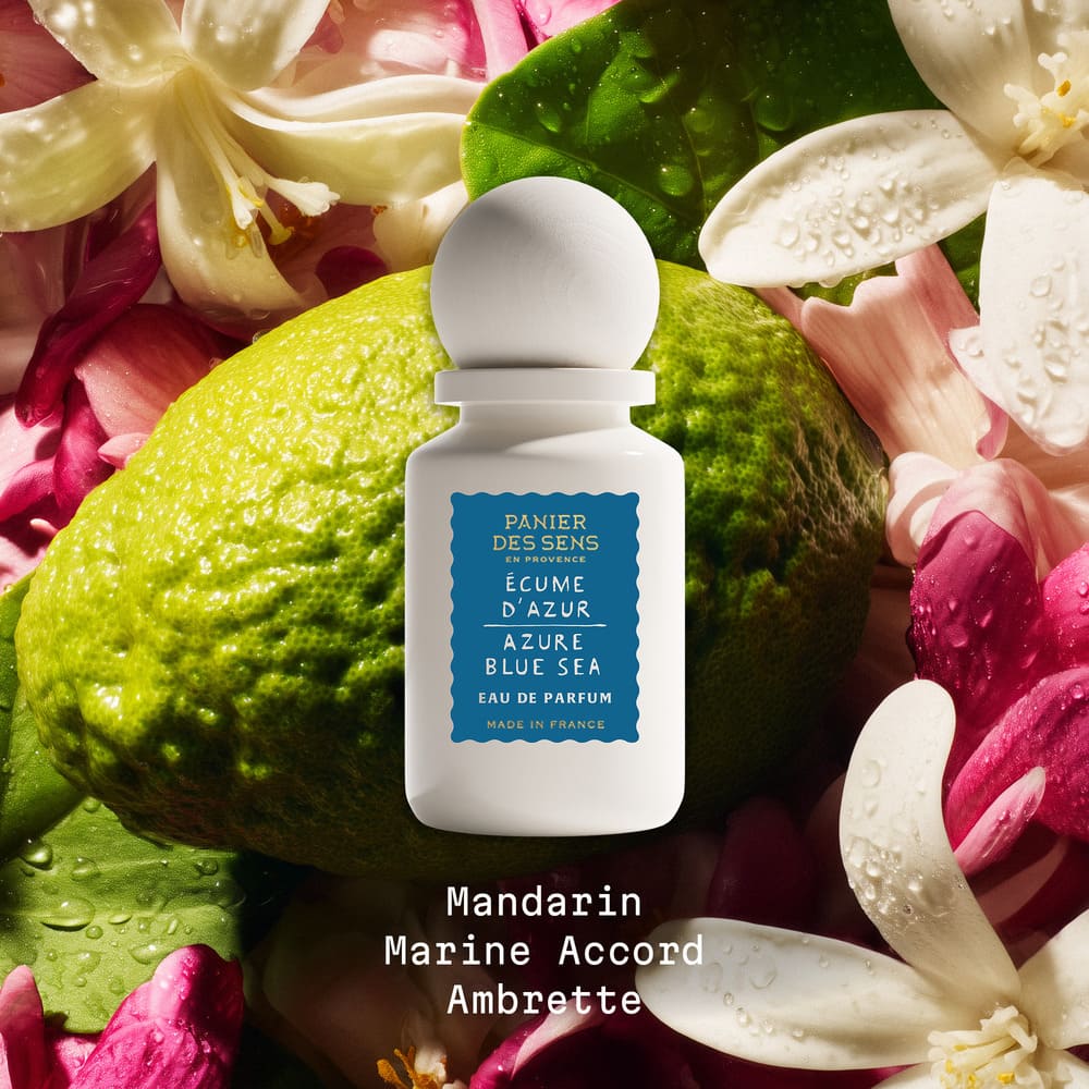 Azure Blue Sea white perfume bottle with blue label on green leaves and flowers