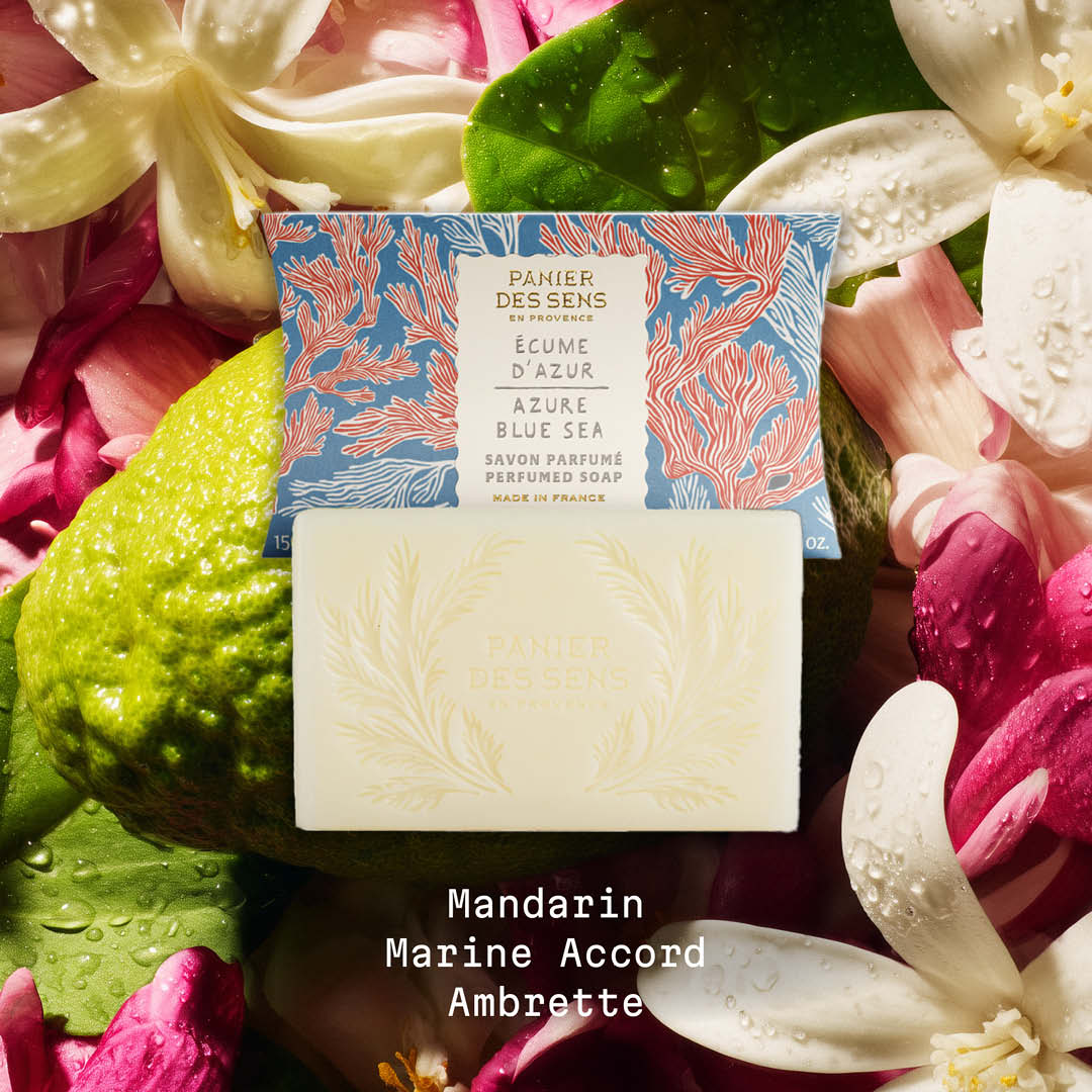 Bar of soap with packaging on a bed of flowers and leaves