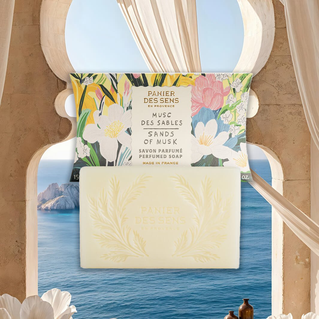 Sands of musk soap bar with floral packaging against a scenic ocean backdrop