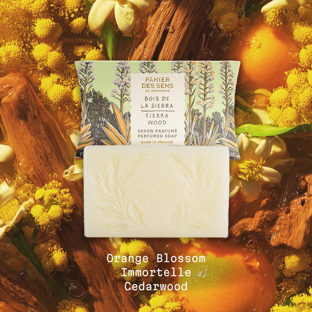 Sierra Wood Bar of soap with packaging on a natural background with flowers and wood.