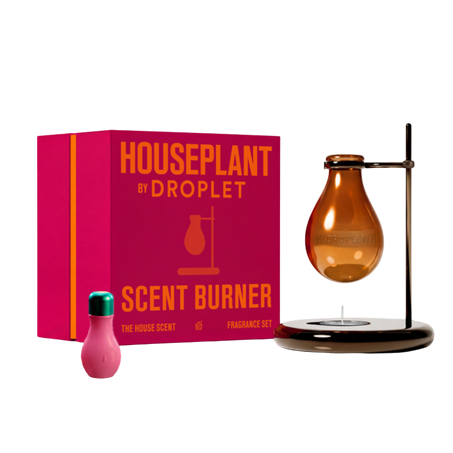 Houseplant by Droplet Scent Burner fragrance set featuring a bright pink box with orange text, an amber glass droplet-style diffuser on a black stand, and a small pink bottle with a green cap, all shown on a white background.